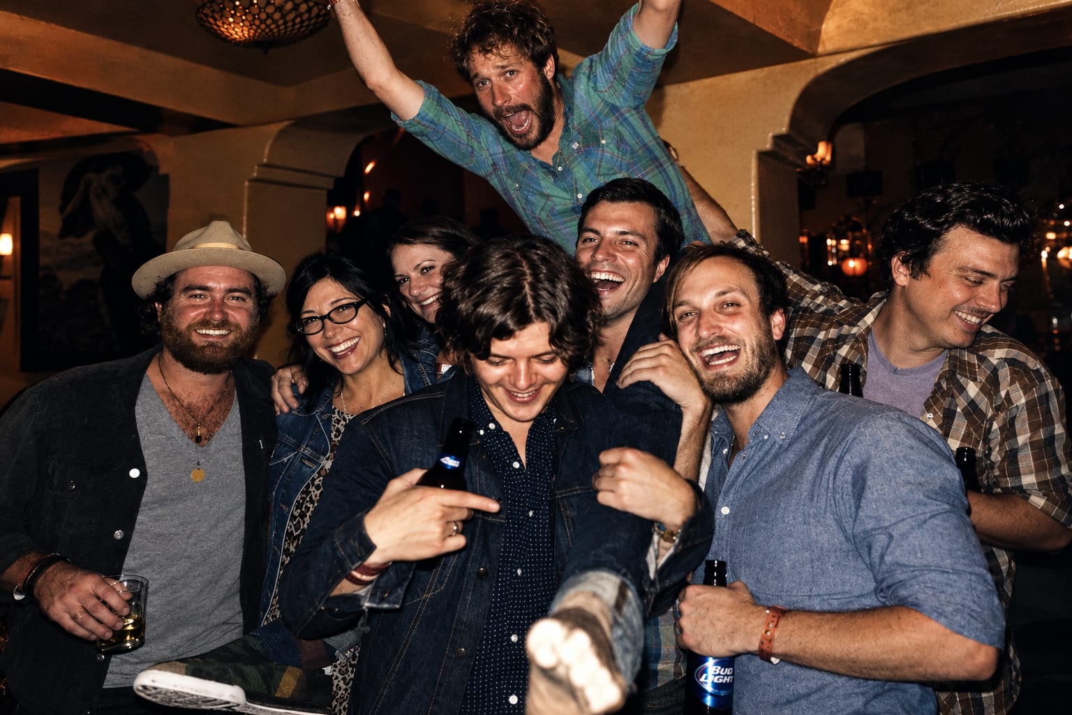 A large group of Wild Feathers members and friends laughing together during an album-release celebration in Los Angeles.