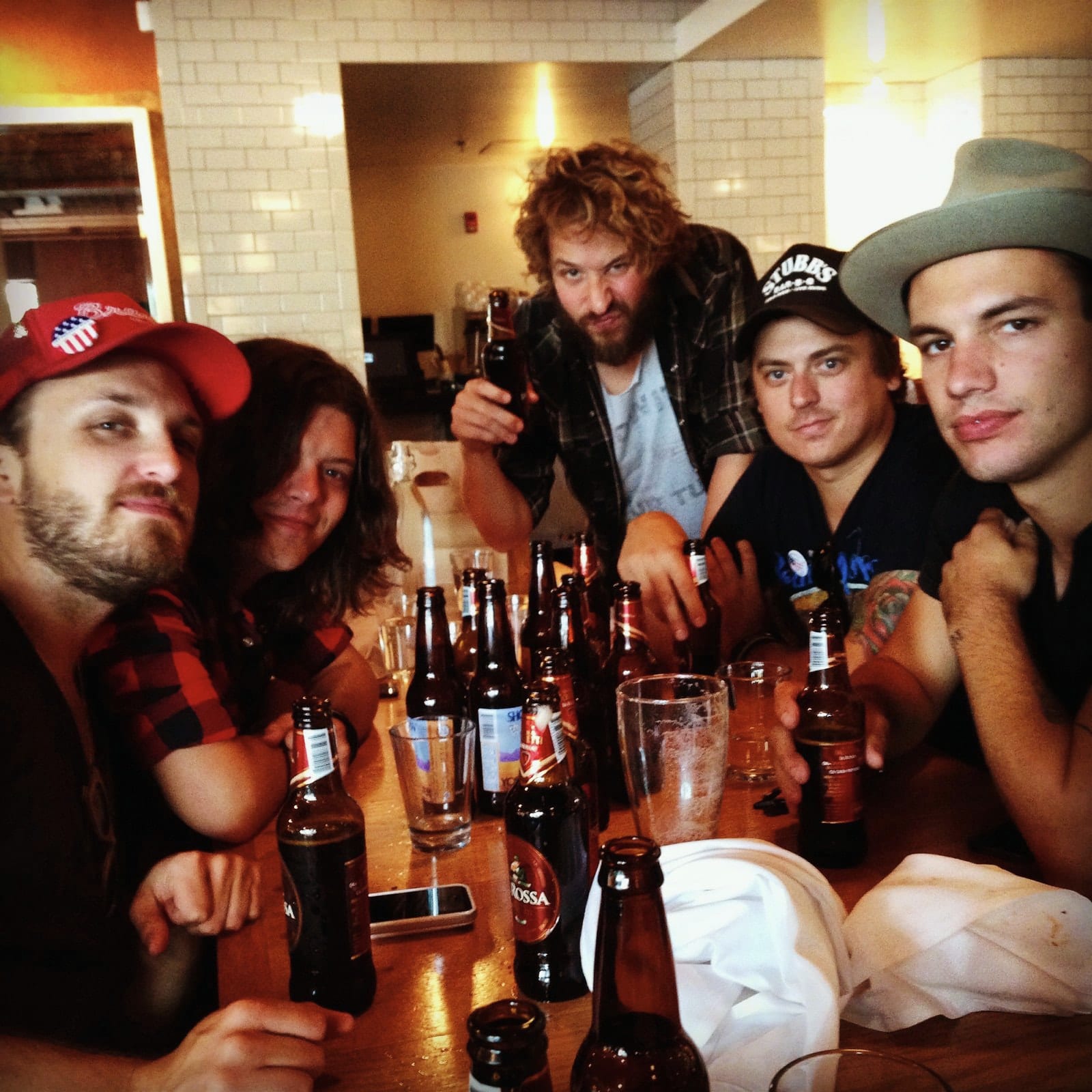 Members of The Wild Feathers and companions gathered around a restaurant table in Ann Arbor.