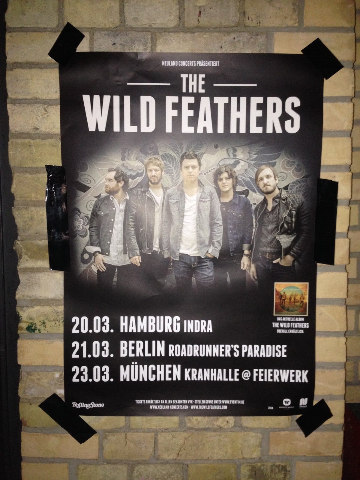 A Wild Feathers European tour poster listing Hamburg, Berlin, and Munich dates.