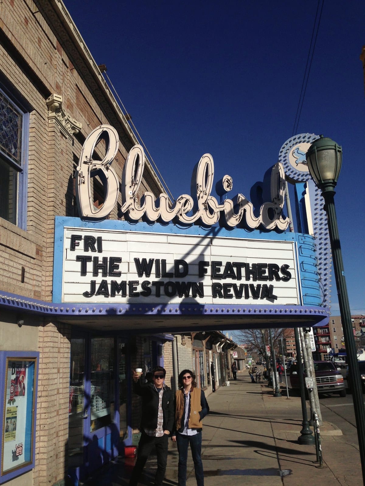 Members of The Wild Feathers standing beneath the Bluebird Theater marquee in Denver.