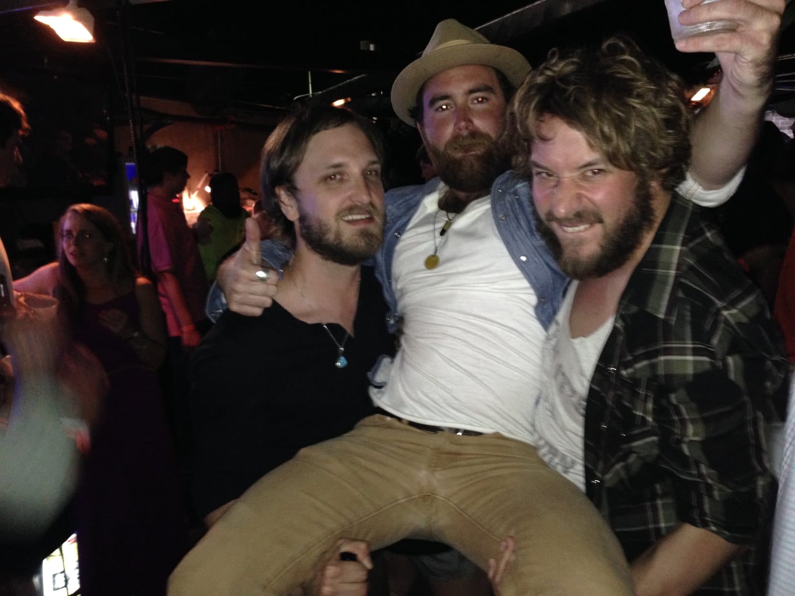 Members of The Wild Feathers and friends posing together backstage at the Double Decker festival in Oxford.