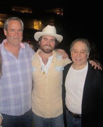 The founding guitarist standing between his father and Paul Simon after the final show of the run.