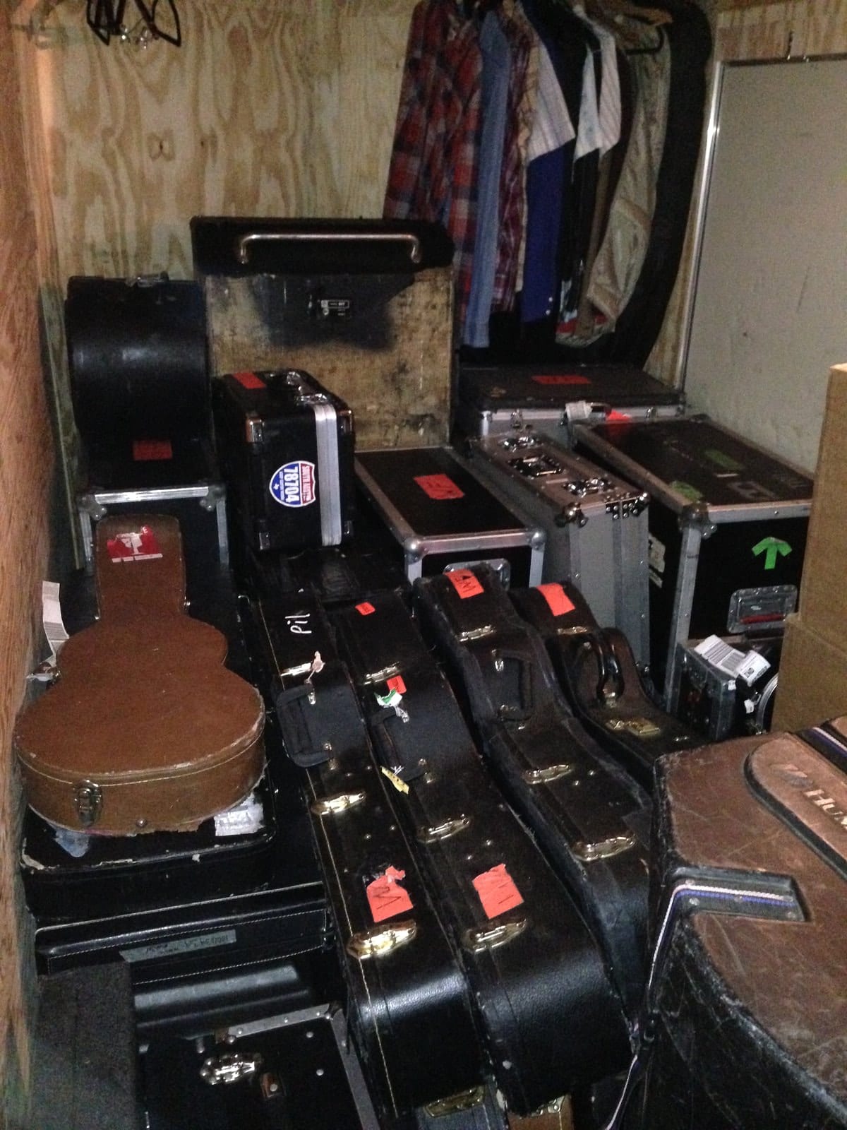 Open and closed guitar cases packed into a backstage room in Indianapolis.