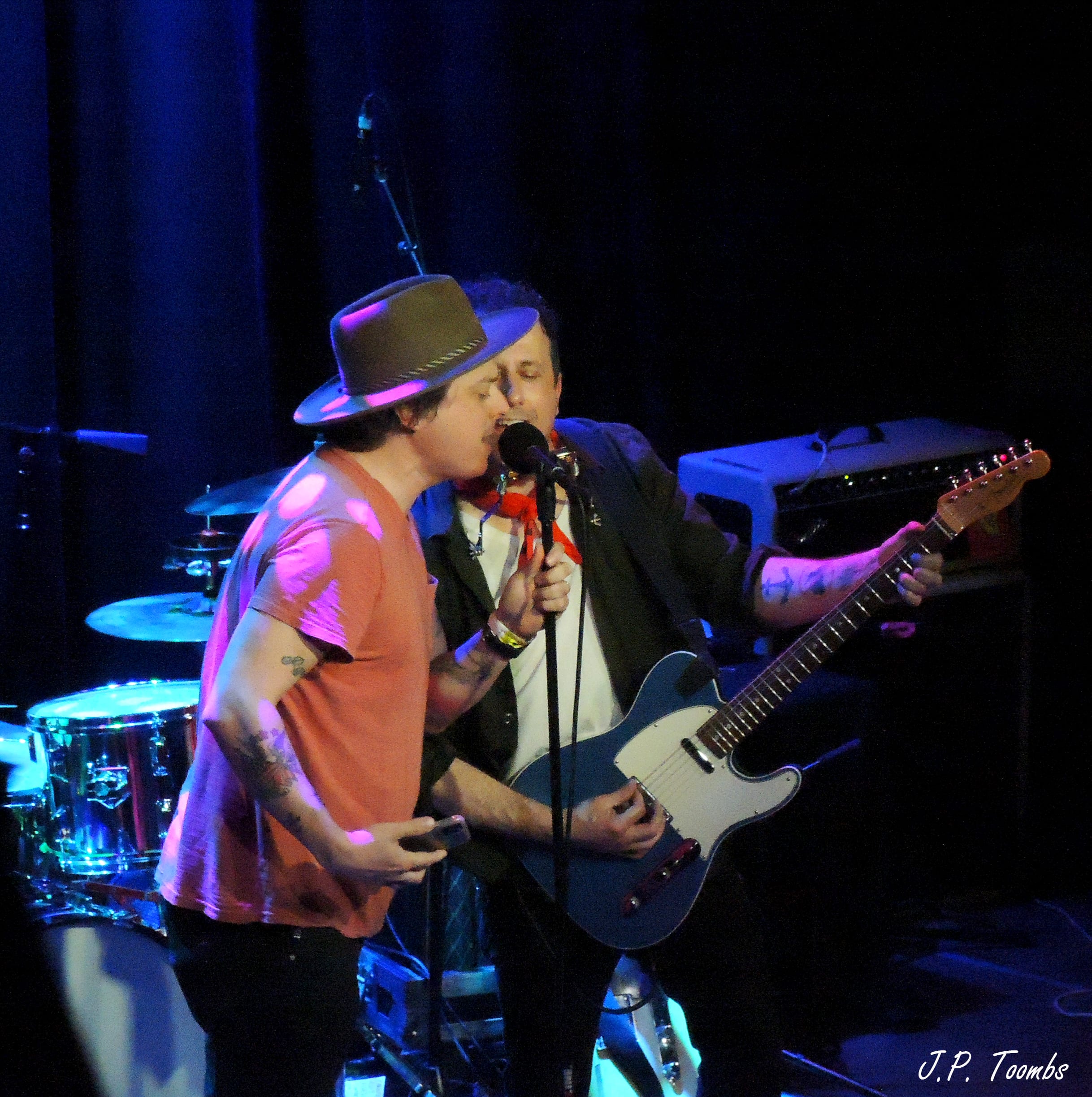 Two musicians share a microphone during the collaborative closing portion of the Midway Motel Tour show in Columbus.