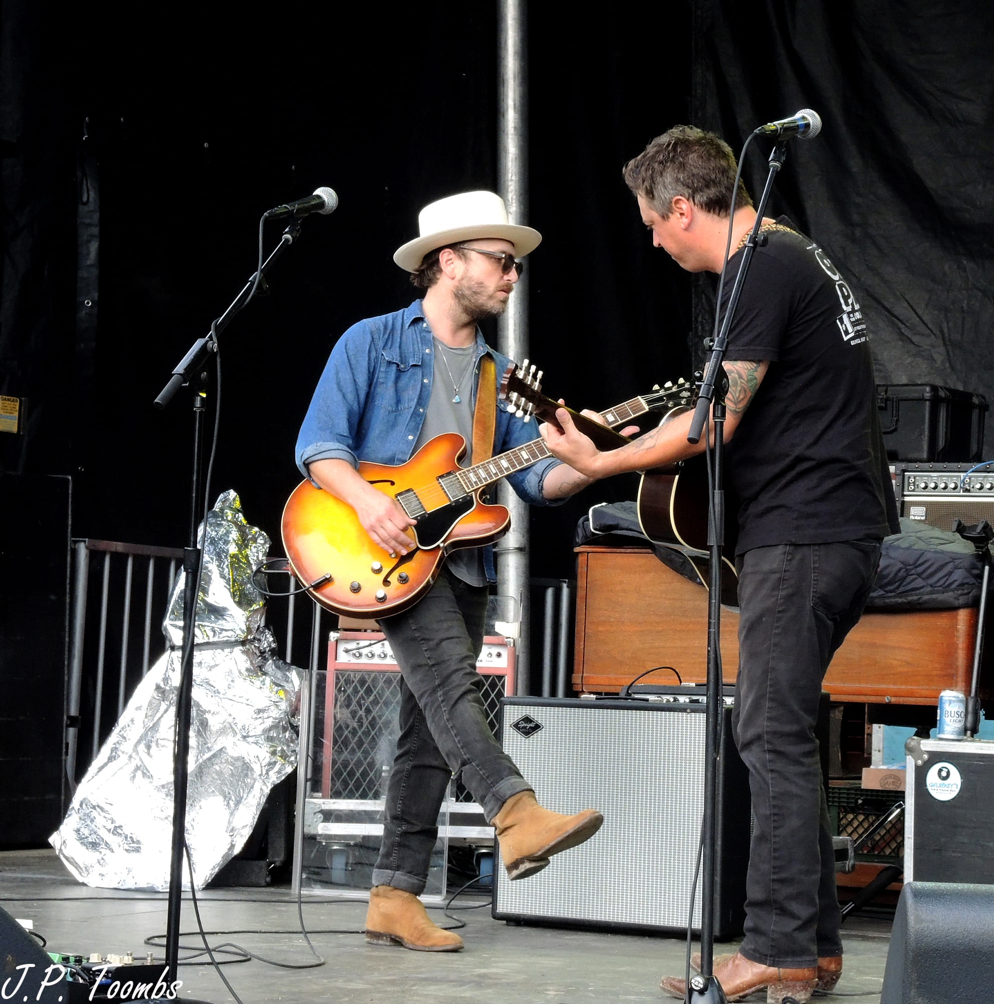 A Wild Feathers guitarist lifts one boot while playing at the front of the Rock the Ruins stage in Indianapolis.