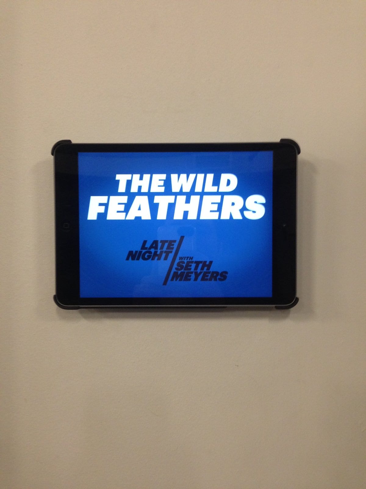 A wall-mounted screen identifying The Wild Feathers and Late Night with Seth Meyers.