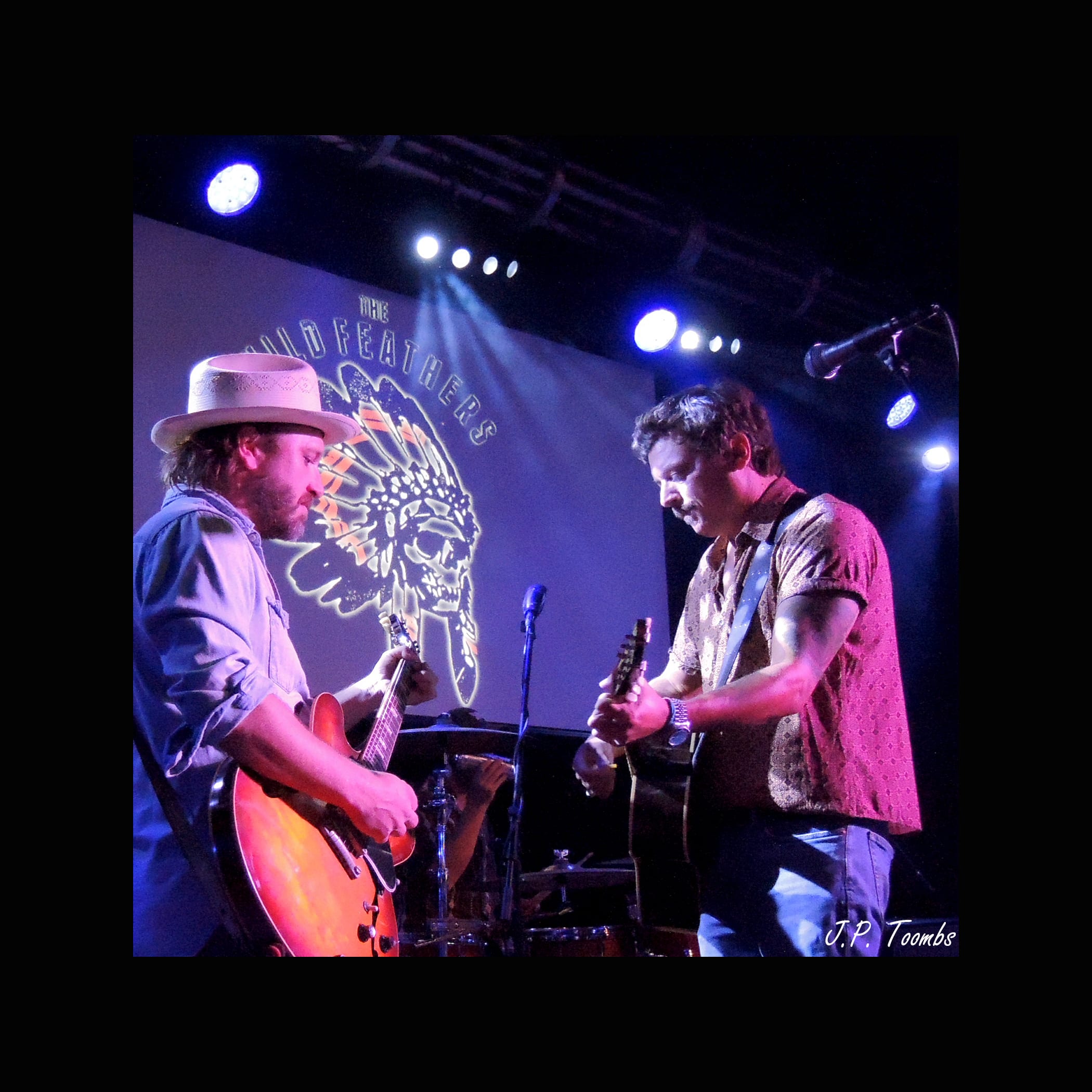 Two Wild Feathers guitarists face one another beneath the venue lights during the July 5 performance at 3rd & Lindsley.
