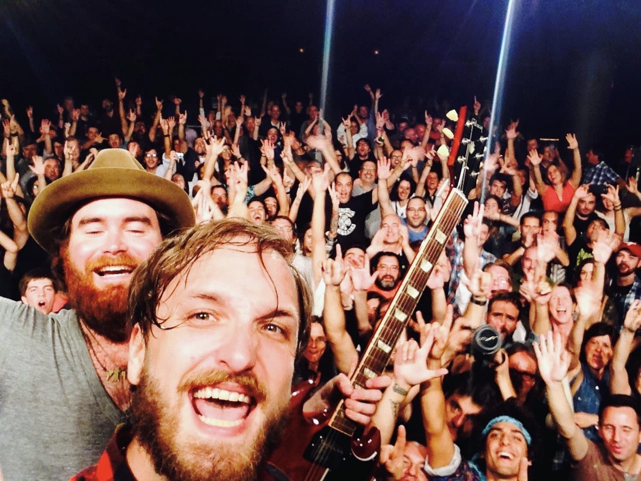 The founding guitarist and Ben Dumas taking a stage self-portrait with a cheering Barcelona audience behind them.