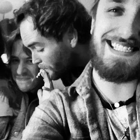 A black-and-white square group selfie of four members of The Wild Feathers.