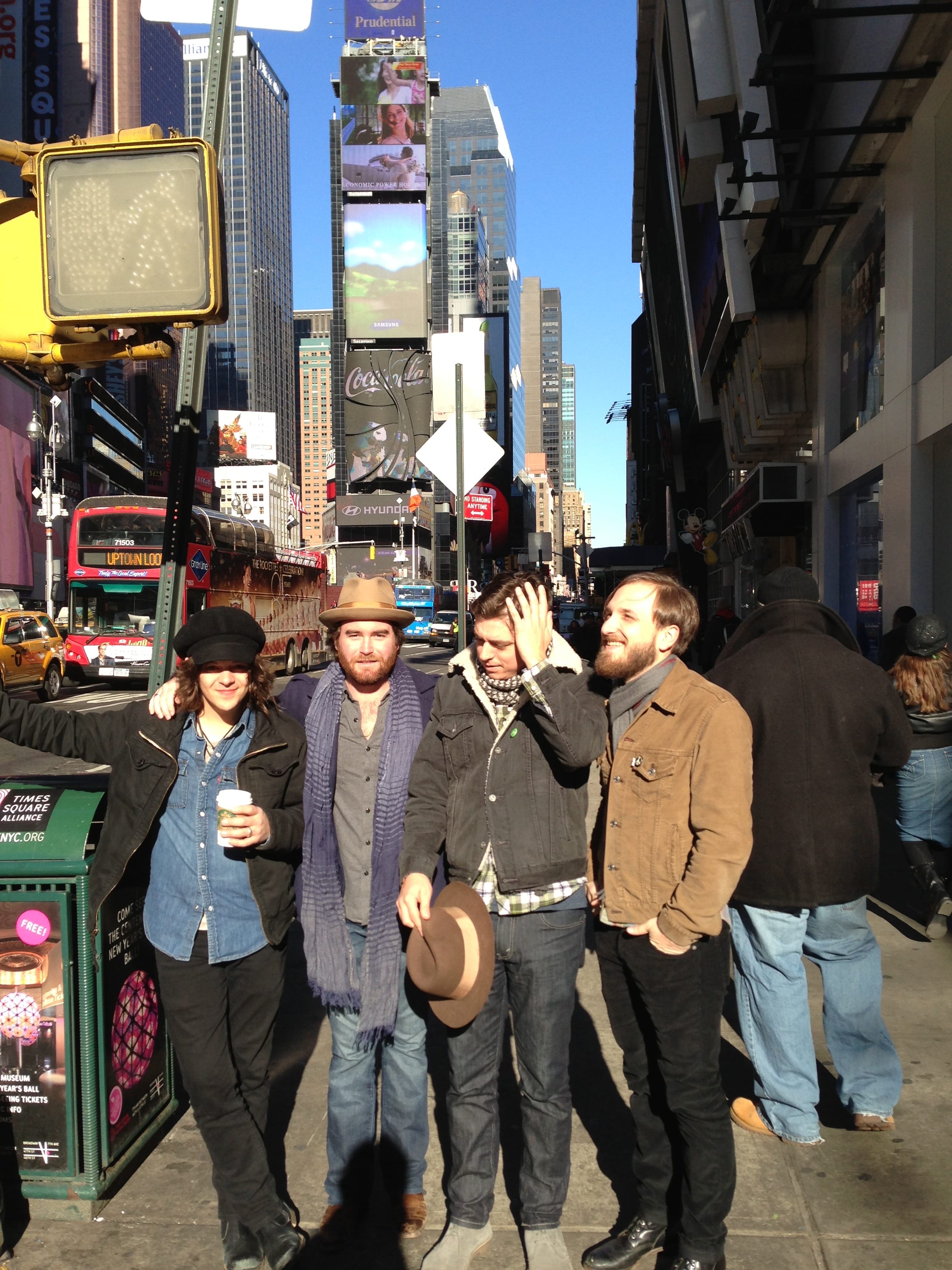 Four members of The Wild Feathers standing together on a Times Square street.